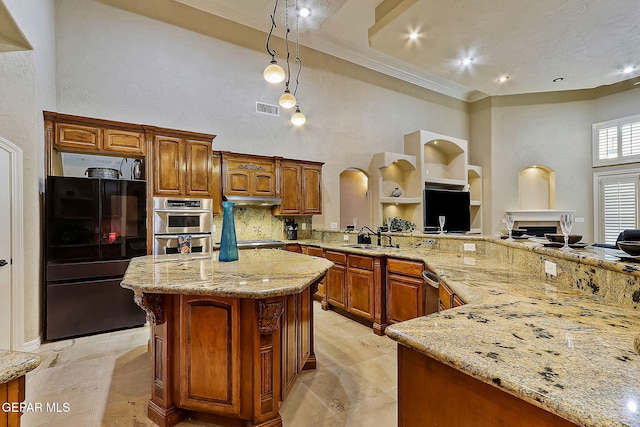 kitchen with light stone countertops, a towering ceiling, stainless steel appliances, decorative light fixtures, and built in features