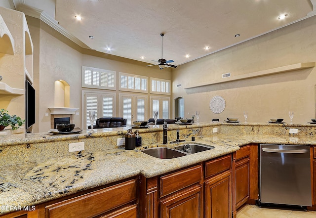 kitchen featuring light stone countertops, stainless steel dishwasher, ceiling fan, and sink