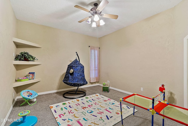 playroom featuring dark colored carpet and ceiling fan