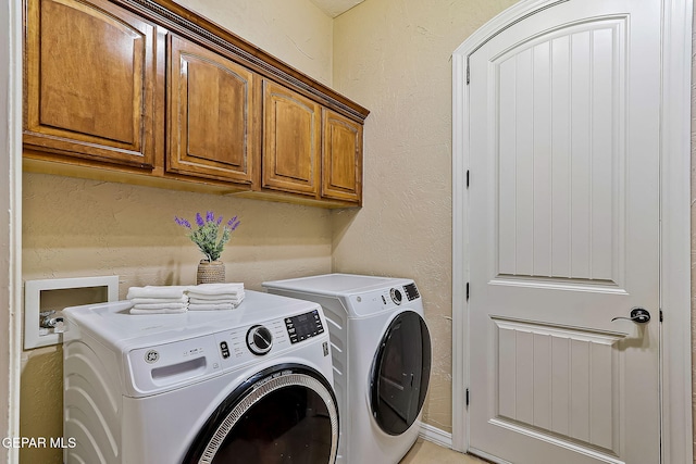 clothes washing area with cabinets and washer and dryer