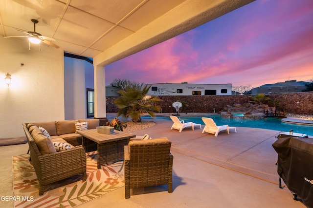 patio terrace at dusk with an outdoor living space, area for grilling, a fenced in pool, and ceiling fan