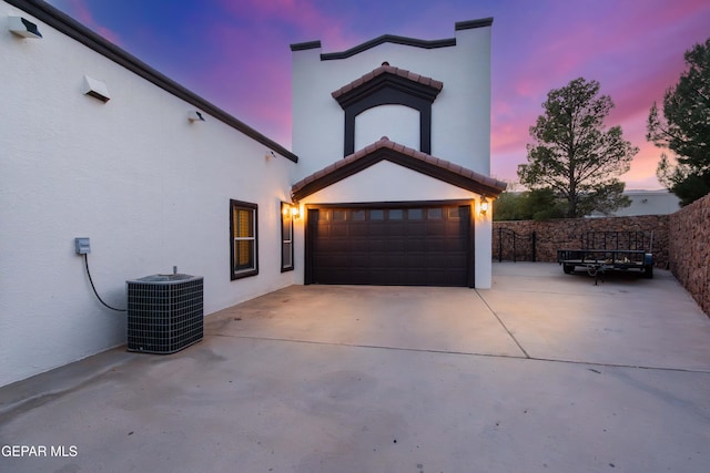 garage at dusk featuring central AC