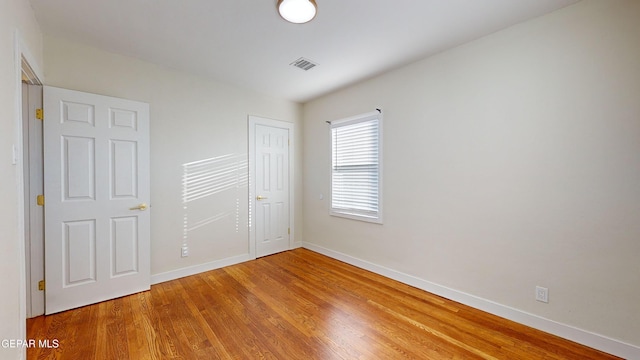 unfurnished bedroom featuring wood-type flooring and a closet