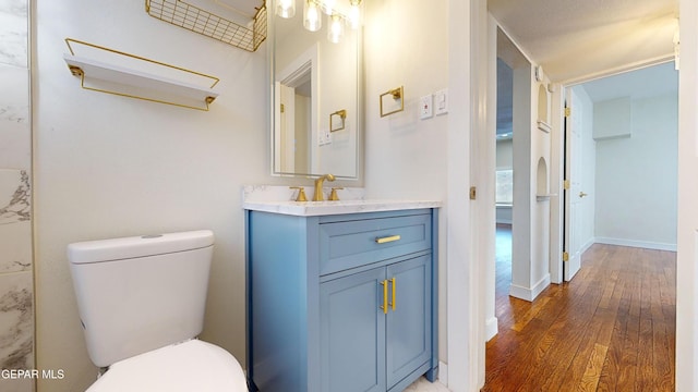 bathroom with vanity, a textured ceiling, hardwood / wood-style flooring, and toilet