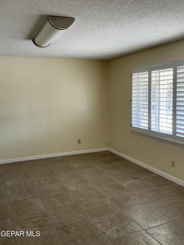 spare room with a textured ceiling