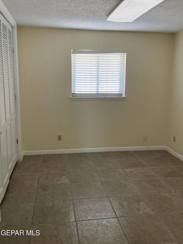 unfurnished bedroom with a textured ceiling and a closet