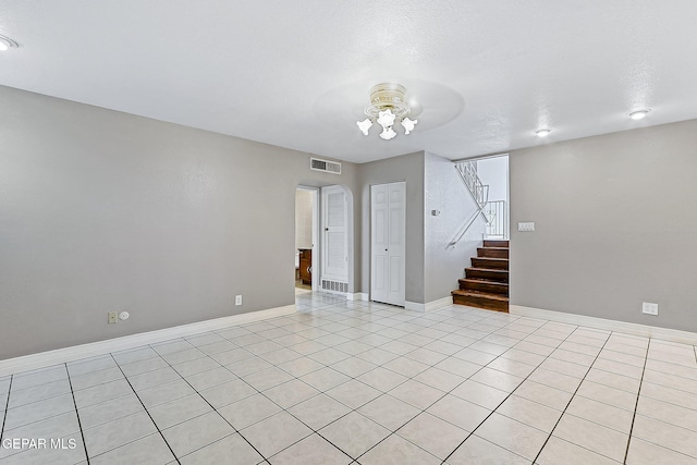 unfurnished room featuring light tile patterned floors and a textured ceiling