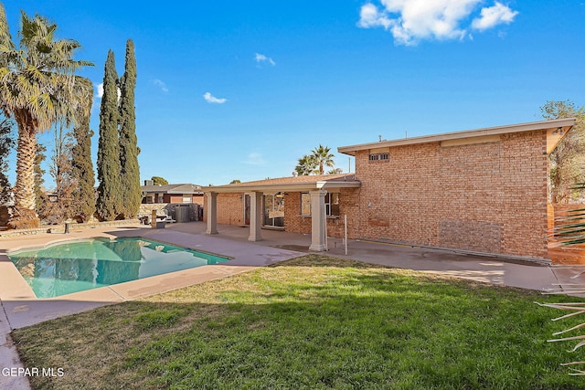 view of swimming pool featuring a yard and a patio