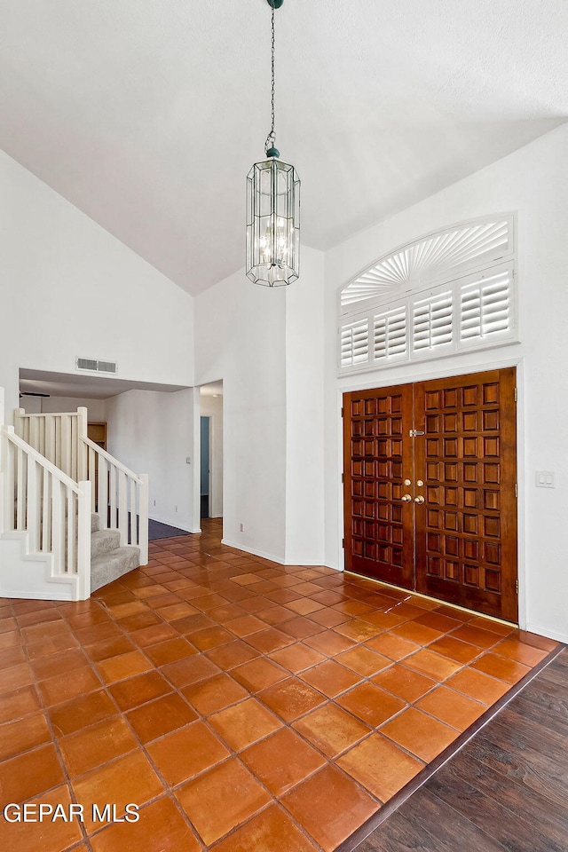 interior space featuring high vaulted ceiling and a chandelier