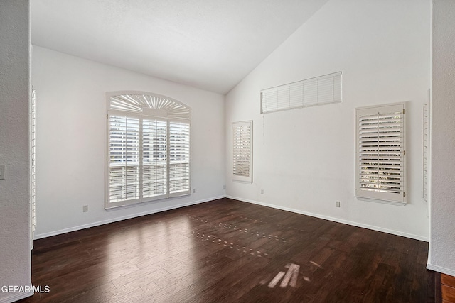 empty room with dark wood-type flooring and lofted ceiling