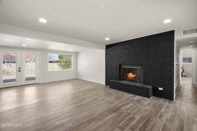 unfurnished living room featuring a fireplace, recessed lighting, visible vents, wood finished floors, and baseboards