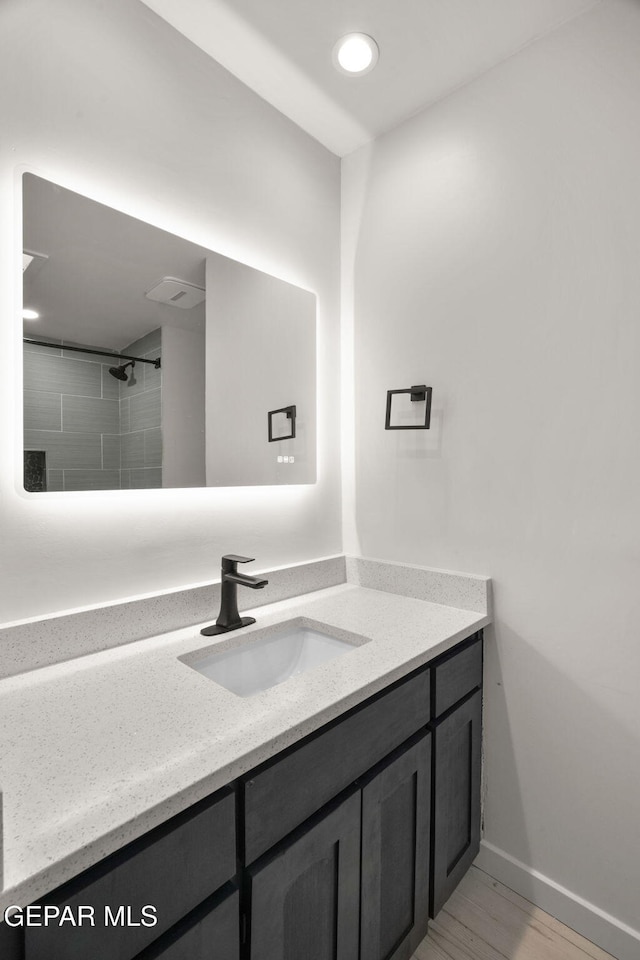 bathroom with recessed lighting, wood finished floors, vanity, and baseboards