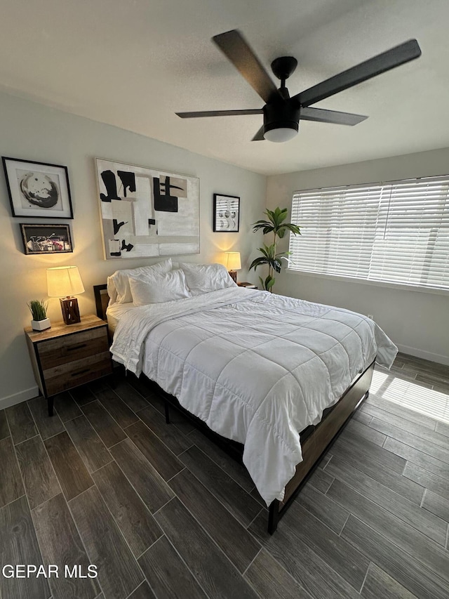 bedroom with wood tiled floor, ceiling fan, and baseboards