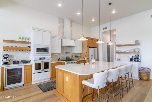 kitchen with wall oven, backsplash, white cabinetry, and beverage cooler