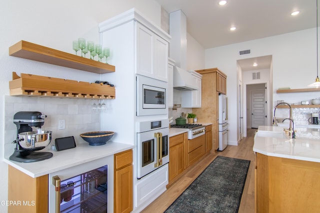 kitchen with tasteful backsplash, white appliances, sink, pendant lighting, and wine cooler