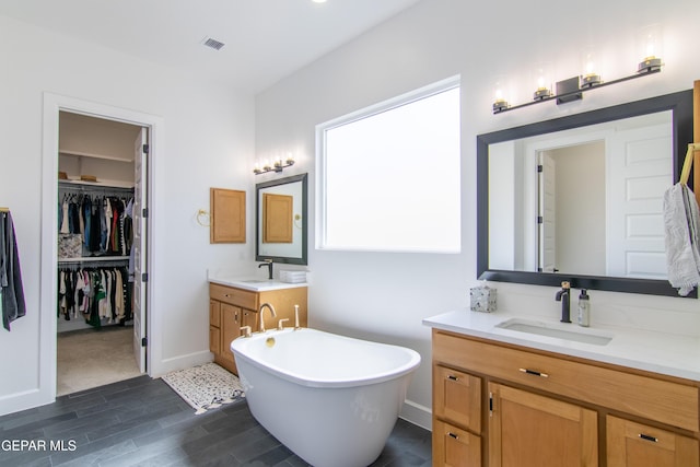 bathroom with vanity and a tub to relax in