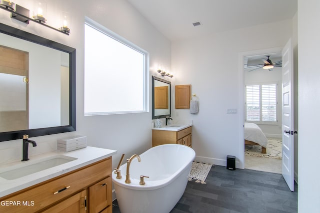 bathroom with ceiling fan, wood-type flooring, a bath, and vanity