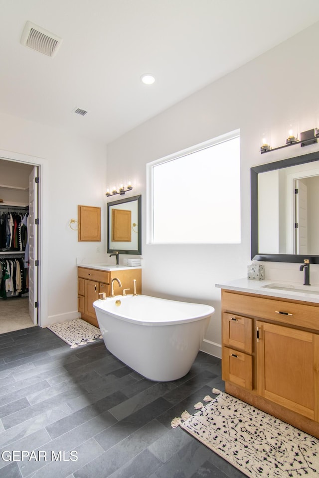 bathroom with vanity and a bath