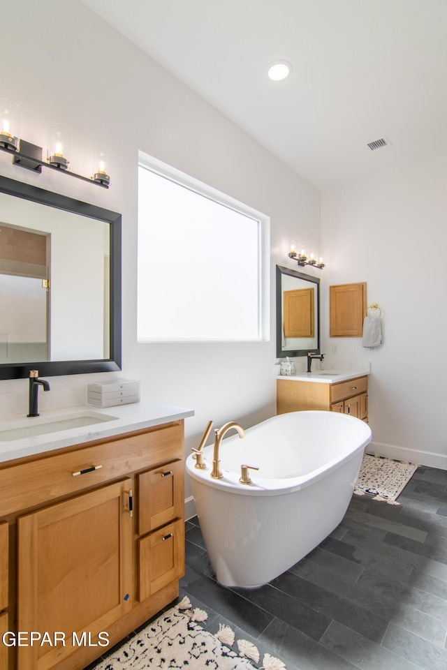 bathroom with a tub, tile patterned flooring, and vanity