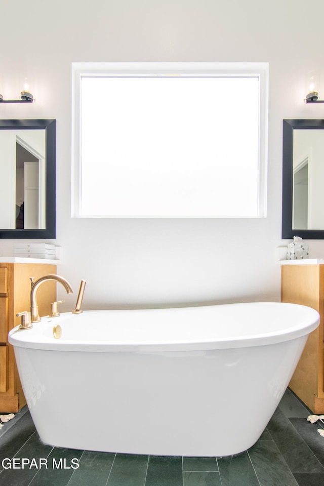 bathroom with vanity, tile patterned floors, and a bathing tub