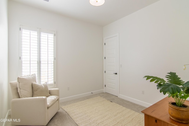 living area featuring light carpet