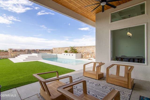 view of patio with a fenced in pool and ceiling fan