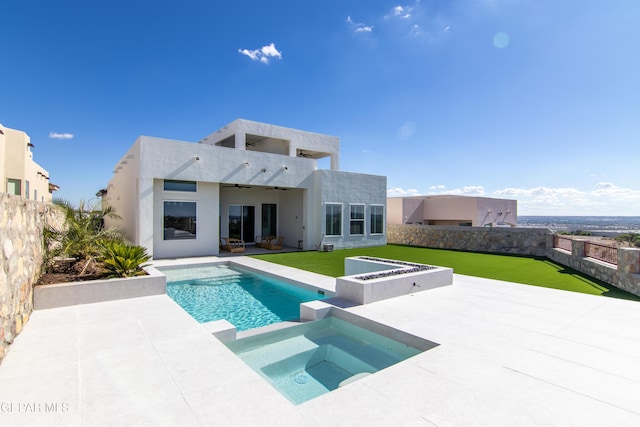 back of property with a yard, a patio area, and a pool with hot tub