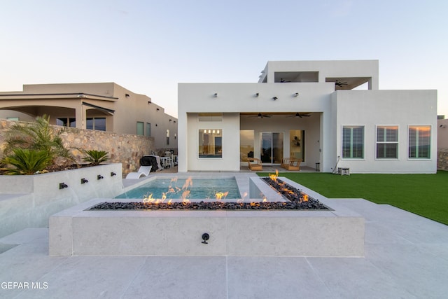 rear view of property with a yard, a patio, ceiling fan, and an outdoor fire pit