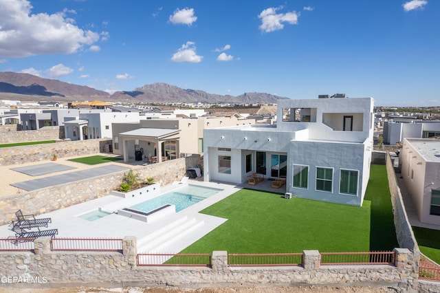 back of house with a mountain view, a patio area, and a yard