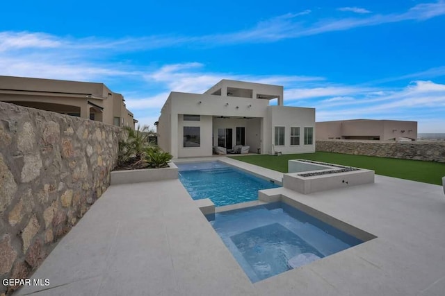 back of property with ceiling fan, a swimming pool with hot tub, and a patio