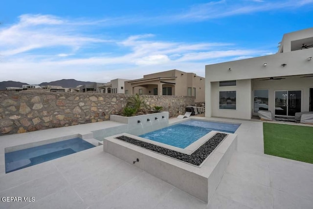 view of swimming pool with an in ground hot tub, a patio, ceiling fan, and an outdoor fire pit