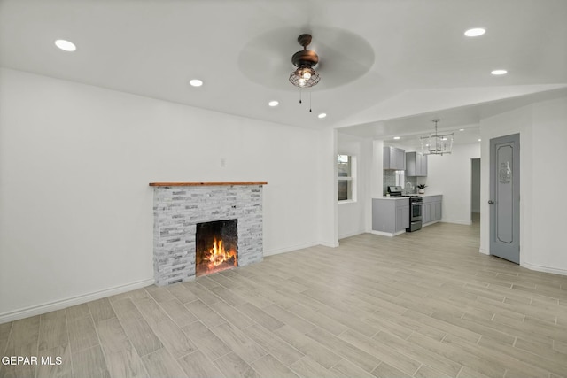 unfurnished living room featuring ceiling fan, light hardwood / wood-style flooring, and lofted ceiling