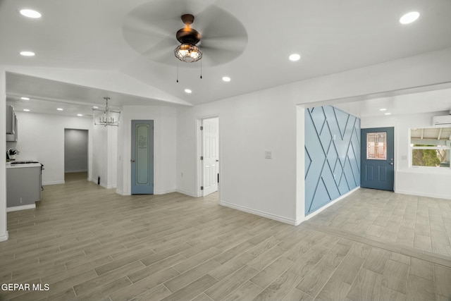 unfurnished living room with ceiling fan with notable chandelier and lofted ceiling