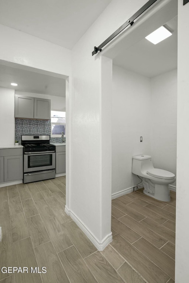 bathroom featuring vanity, backsplash, and toilet