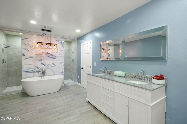 bathroom featuring vanity, independent shower and bath, and tile walls