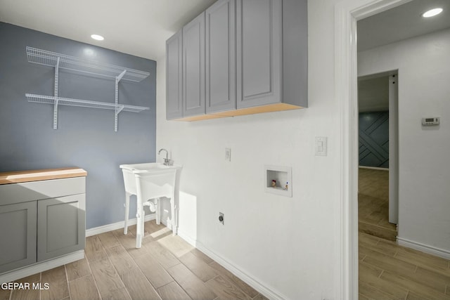 laundry area featuring electric dryer hookup, cabinets, sink, and washer hookup