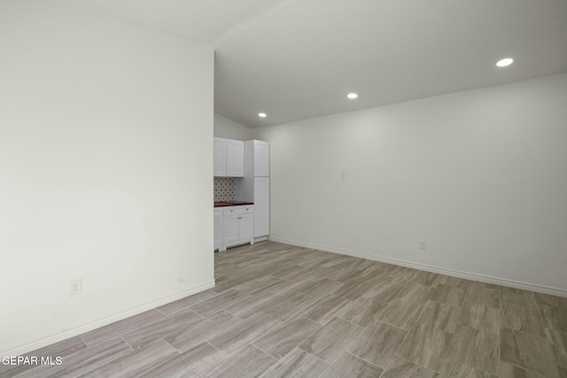 unfurnished room featuring vaulted ceiling