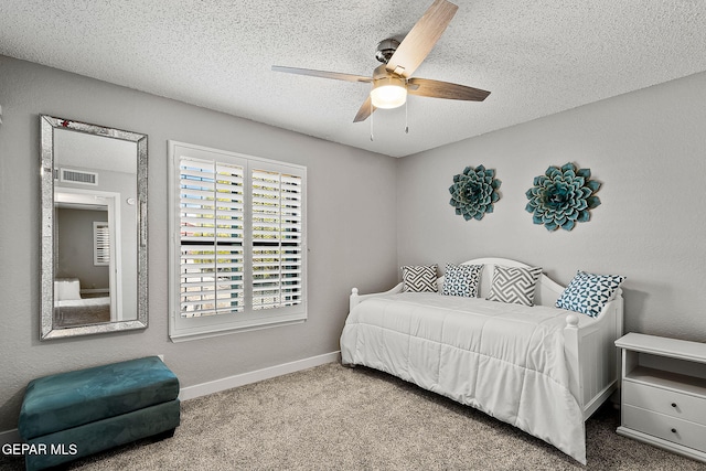 bedroom with ceiling fan, carpet, and a textured ceiling