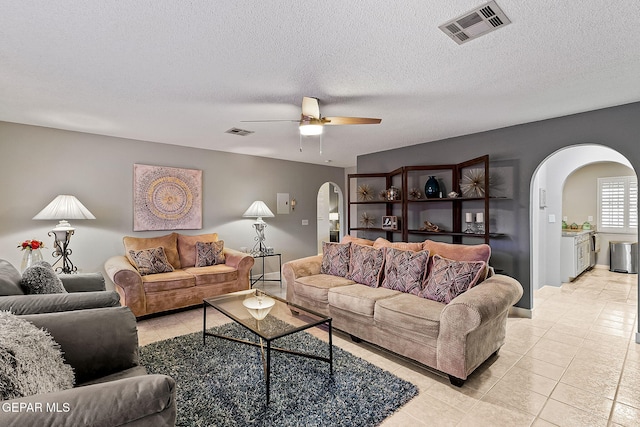 tiled living room featuring a textured ceiling and ceiling fan