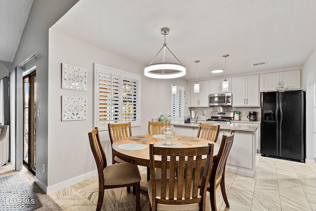 dining area with a wealth of natural light and a textured ceiling