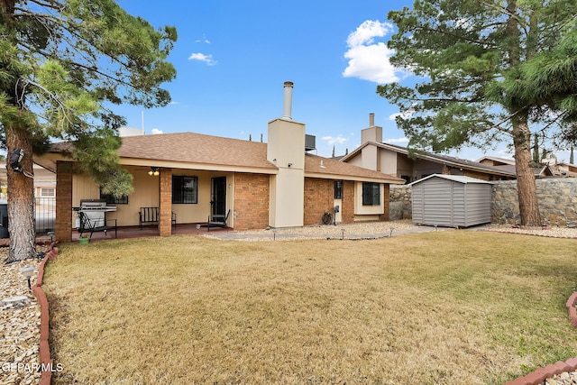 rear view of property with a lawn, a patio area, ceiling fan, and a shed