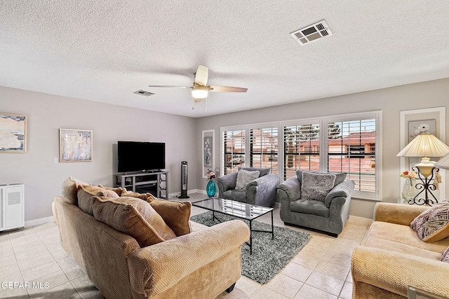 tiled living room with ceiling fan, a textured ceiling, and heating unit