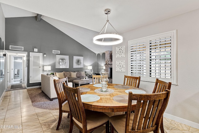 dining room with beamed ceiling, light tile patterned floors, and high vaulted ceiling