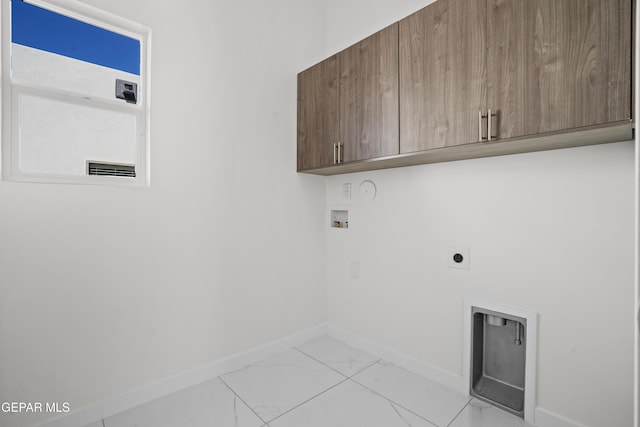 clothes washing area featuring cabinets, hookup for a washing machine, and electric dryer hookup