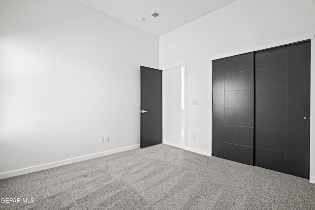 unfurnished bedroom featuring carpet and a closet