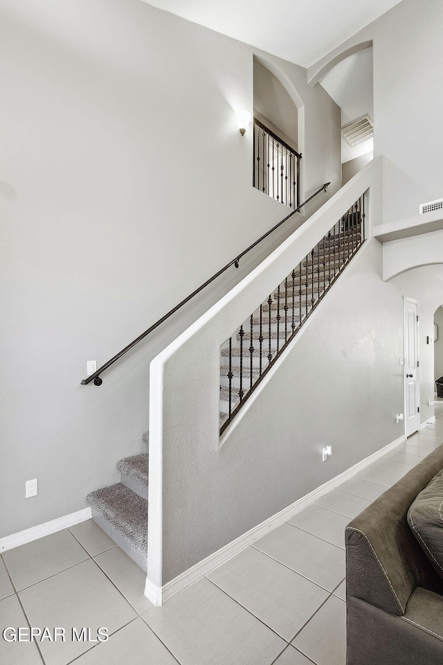 7828 Enchanted View Dr, El Paso, TX 79911 - stairs featuring tile patterned flooring, arched walkways, and high vaulted ceiling