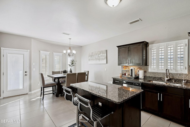 7828 Enchanted View Dr, El Paso, TX 79911 - kitchen with backsplash, light tile patterned flooring, a chandelier, and dark stone counters