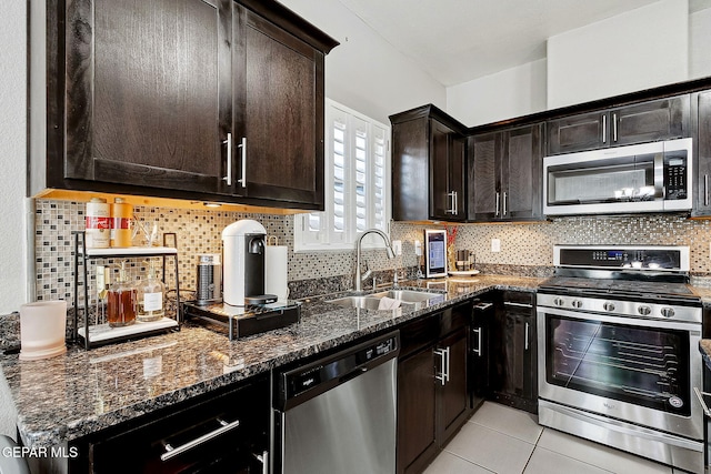 7828 Enchanted View Dr, El Paso, TX 79911 - kitchen featuring stainless steel appliances, dark stone countertops, tasteful backsplash, light tile patterned floors, and dark brown cabinetry