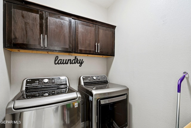 clothes washing area with cabinets and separate washer and dryer