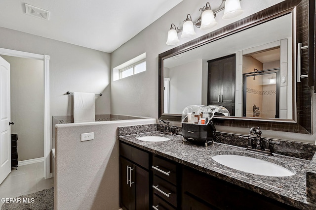 bathroom featuring tile patterned floors, a shower with door, and vanity